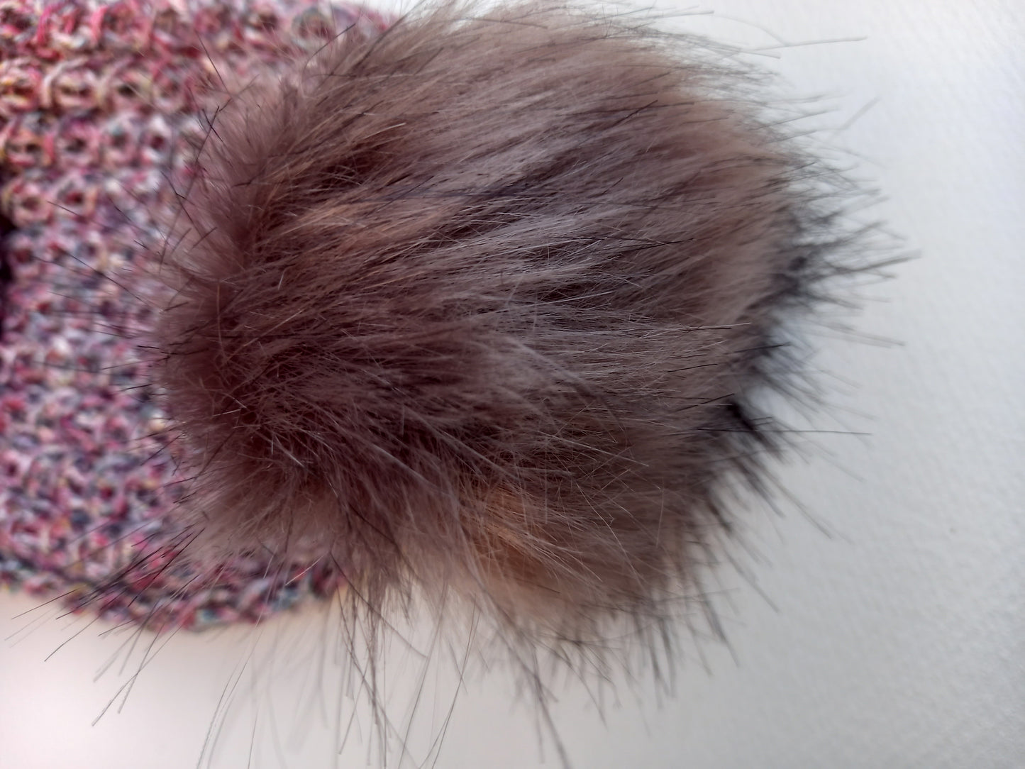A close up of the fluffy faux fur pompom.