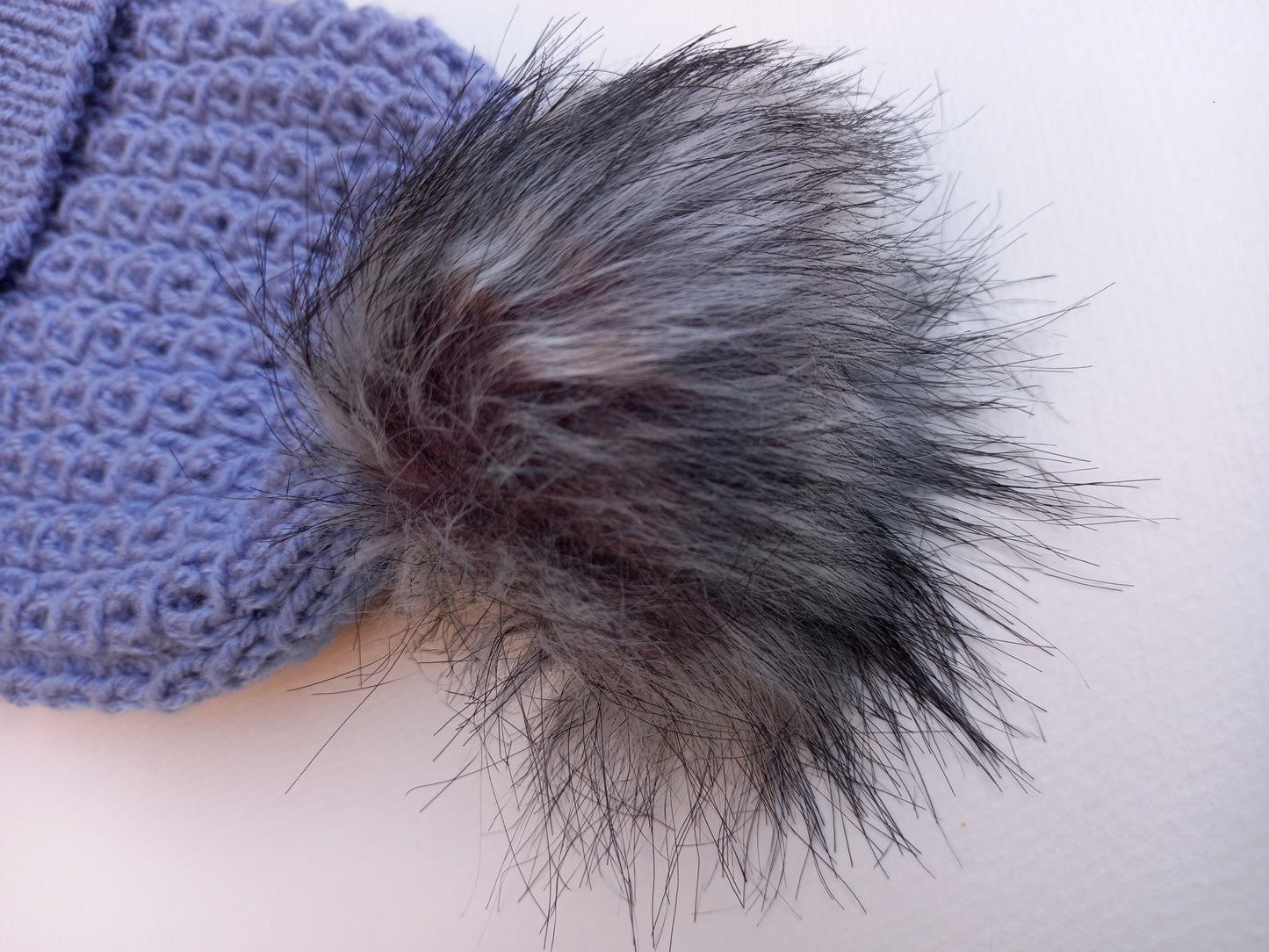 A close up of the grey fluffy pompom.