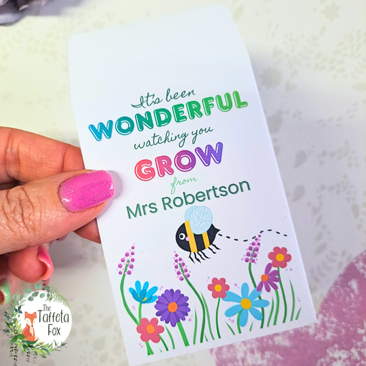 Personalised Watching You Grow teacher wildflower seed packet with colourful flowers and bee illustration.