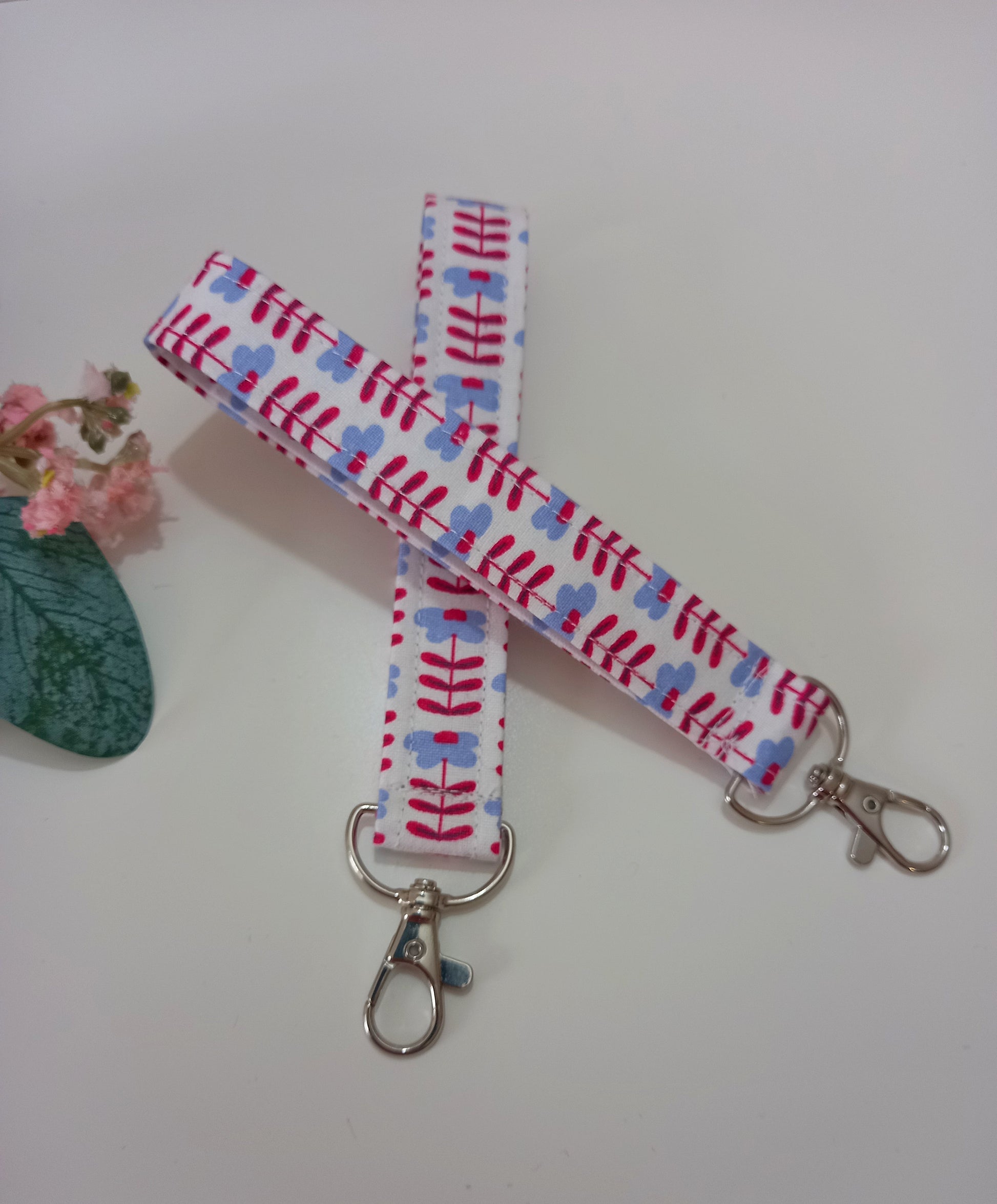 Our fabric wristlet in a white fabric with retro floral pattern with sewn in silver keyfob. 