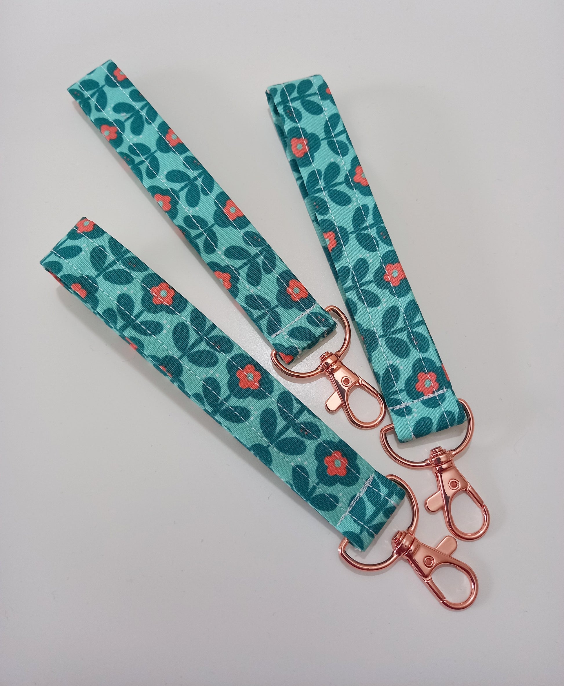 Our fabric wristlet in a green fabric with retro floral pattern with sewn in rose gold keyfob.