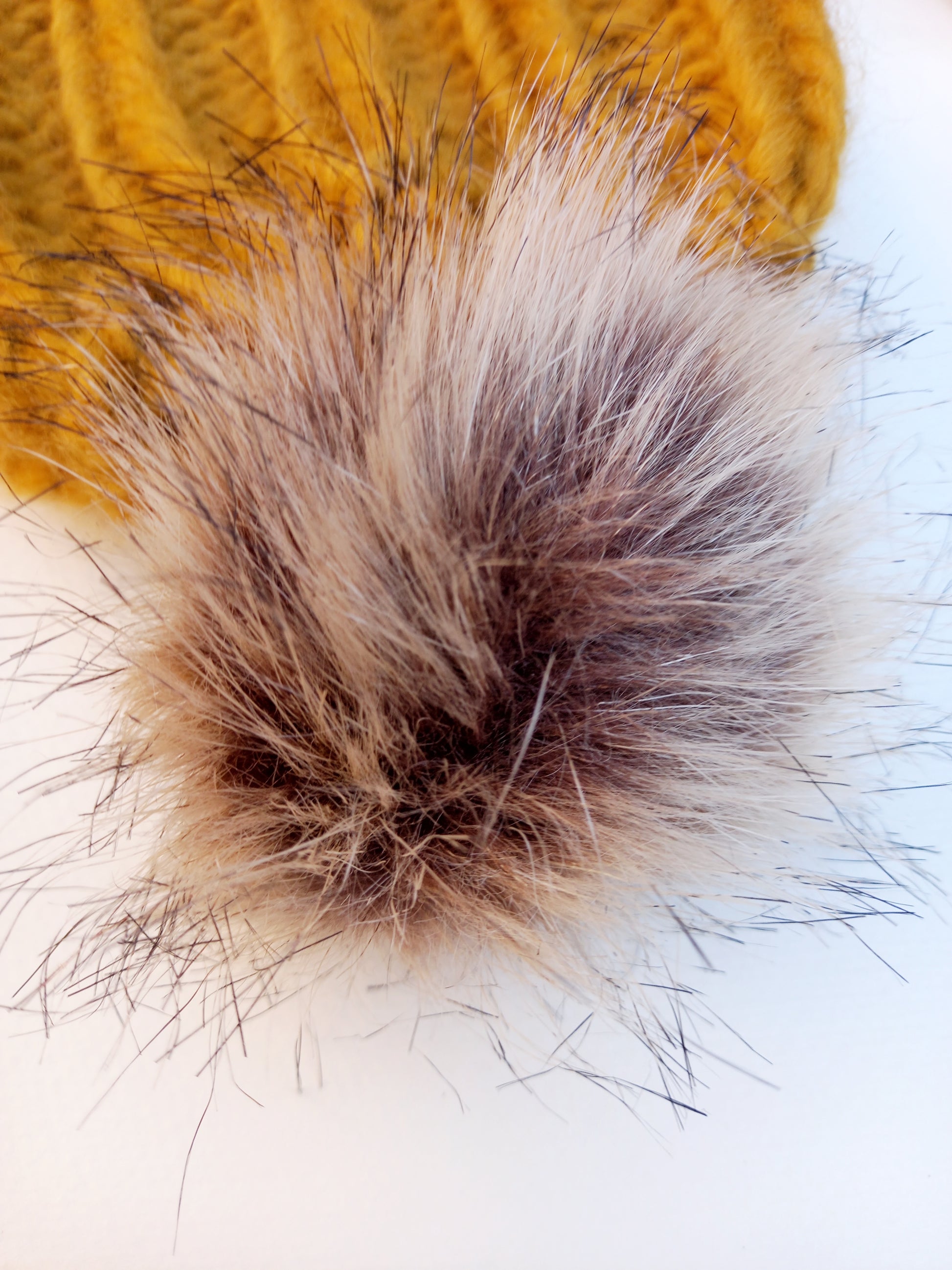 A Close up of the brown fluffy faux fur pompom.