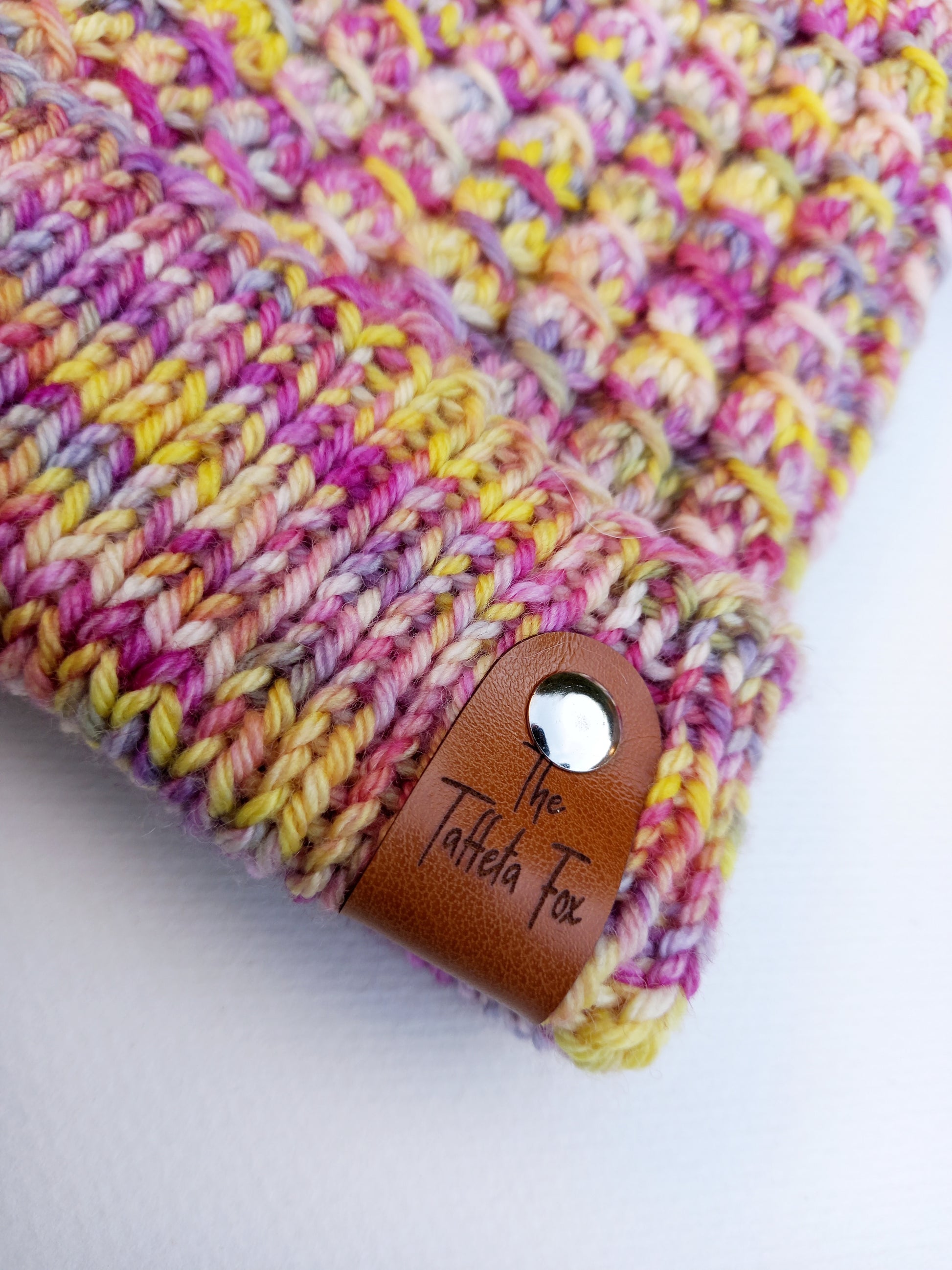 This image shows a close up of the brown faux leather label added to the brim edge of the hat with a small silver rivet which unscrews for washing.